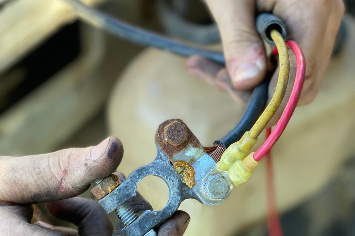 Illustrative example: A corroded battery terminal beside a clean connector being seated into a factory harness, before